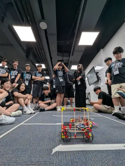 Students cheer a robot along the course